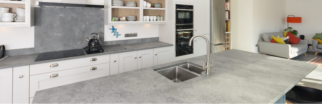 Grey Concrete Quartz worktop with double bowl sink cut-out and chrome tap in a bright modern kitchen