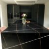 Sahara Noir Quartz island with waterfall ends showing black surface with gold-toned lines and white veining in a modern kitchen