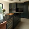 Sahara Noir Quartz island and perimeter worktops in a modern kitchen showing polished black surface with gold-toned lines and white veining