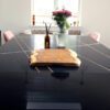 Sahara Noir Quartz island worktop with polished black surface, gold-toned line pattern and white veining shown with a wooden board