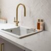 Carrara Quartz worktop with white inset sink and brass tap in a modern kitchen