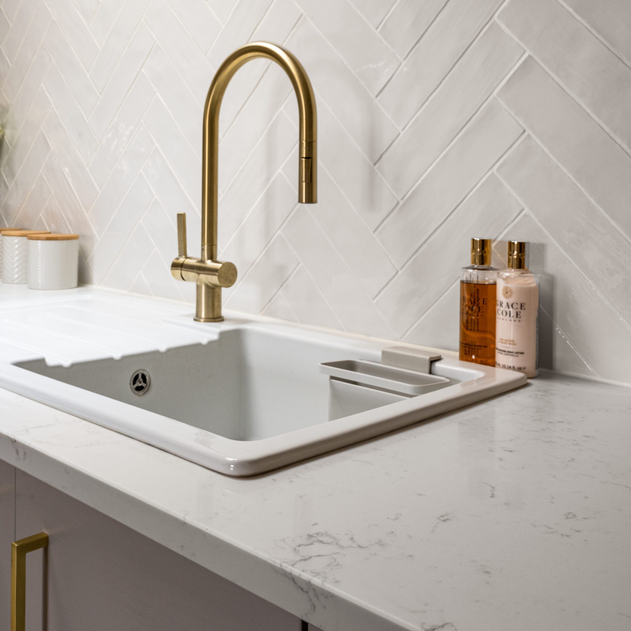 Carrara Quartz worktop with white inset sink and brass tap in a modern kitchen