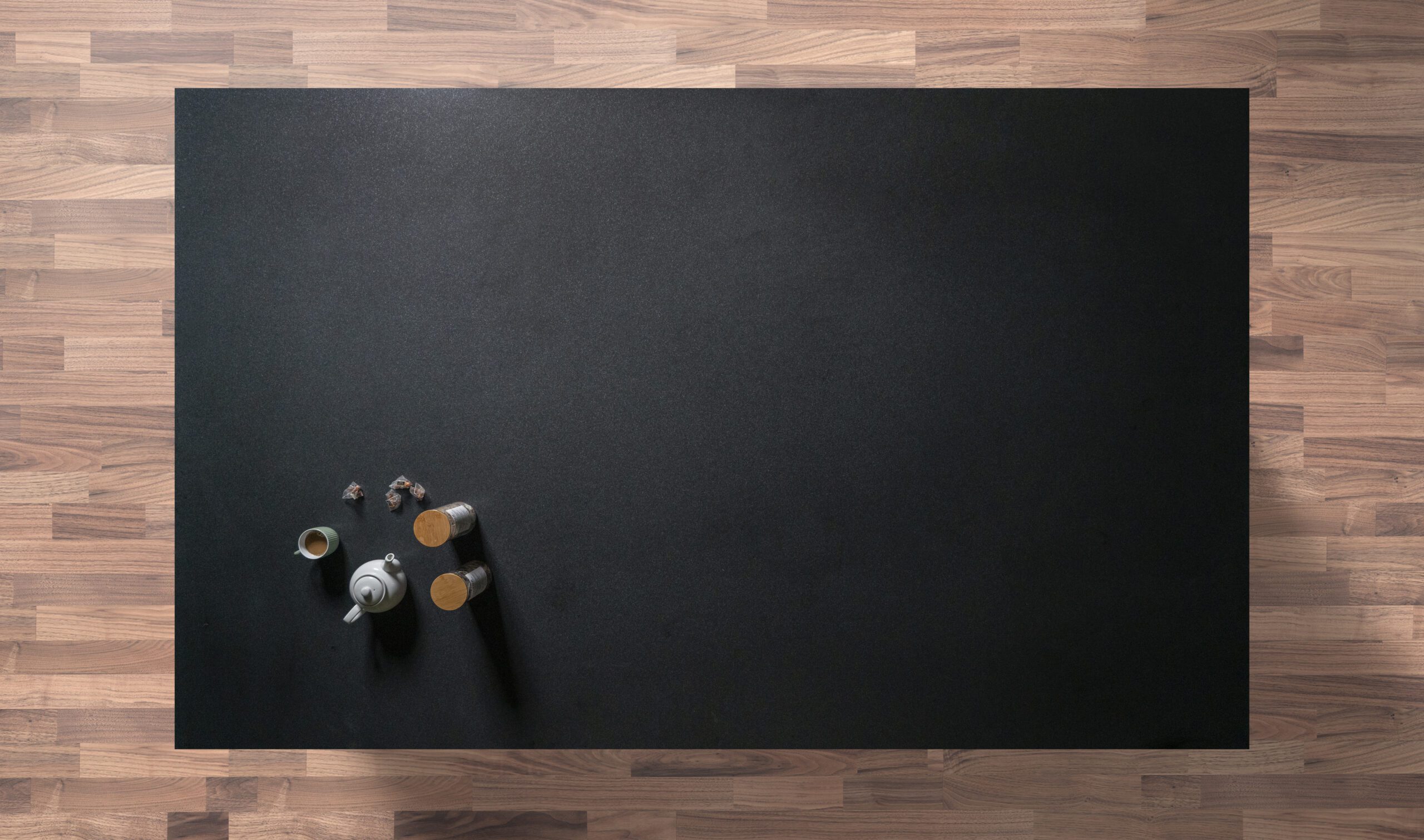 Overhead view of a honed Absolute Black Granite worktop showing a matte black surface, photographed from above with a small styled tray in the corner.