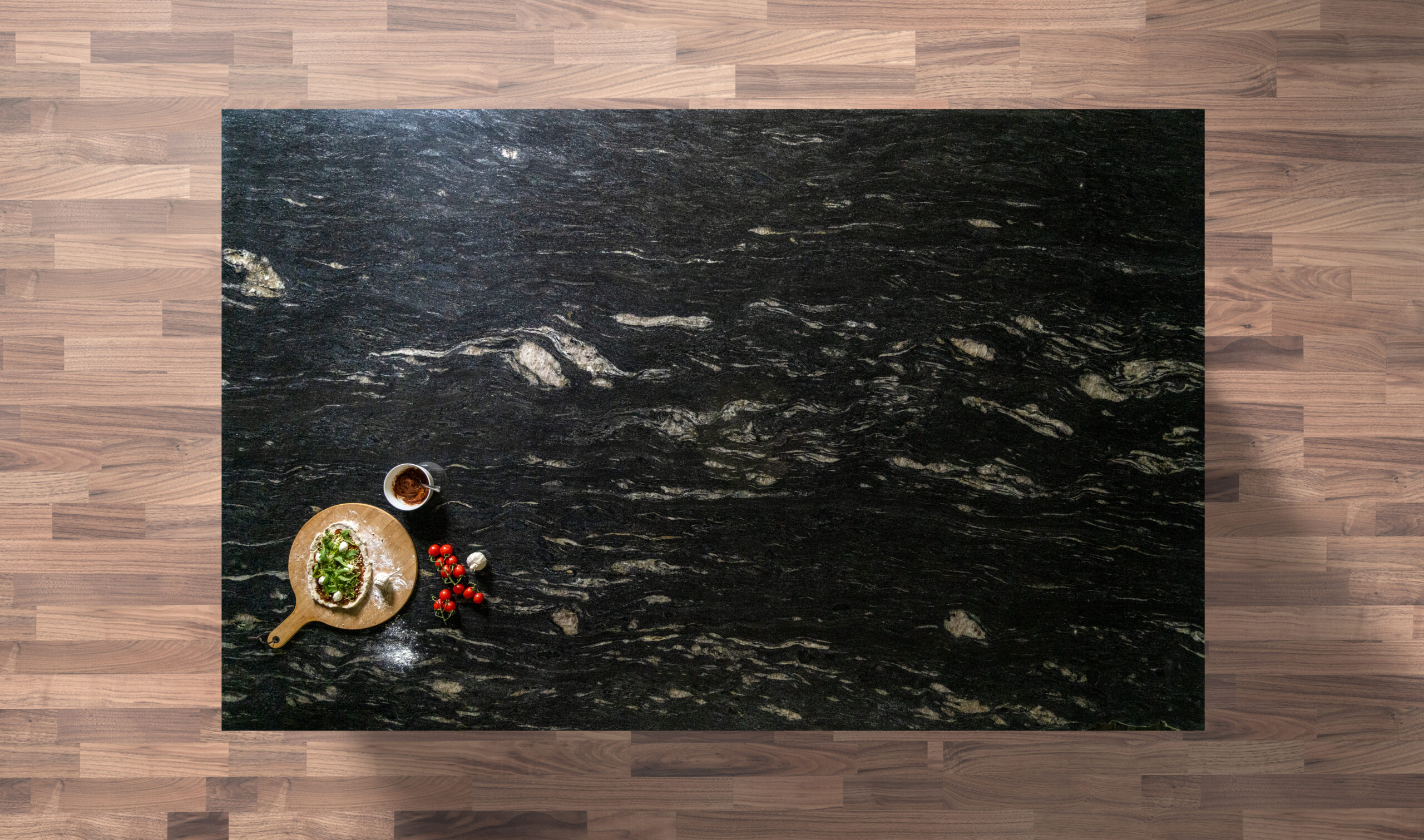 Overhead view of Cosmic Black Granite worktop showing bold natural veining and mineral movement, photographed from above with a small styled tray in the corner.