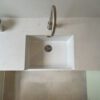Carrara Quartz worktop around a white inset sink in a contemporary laundry room
