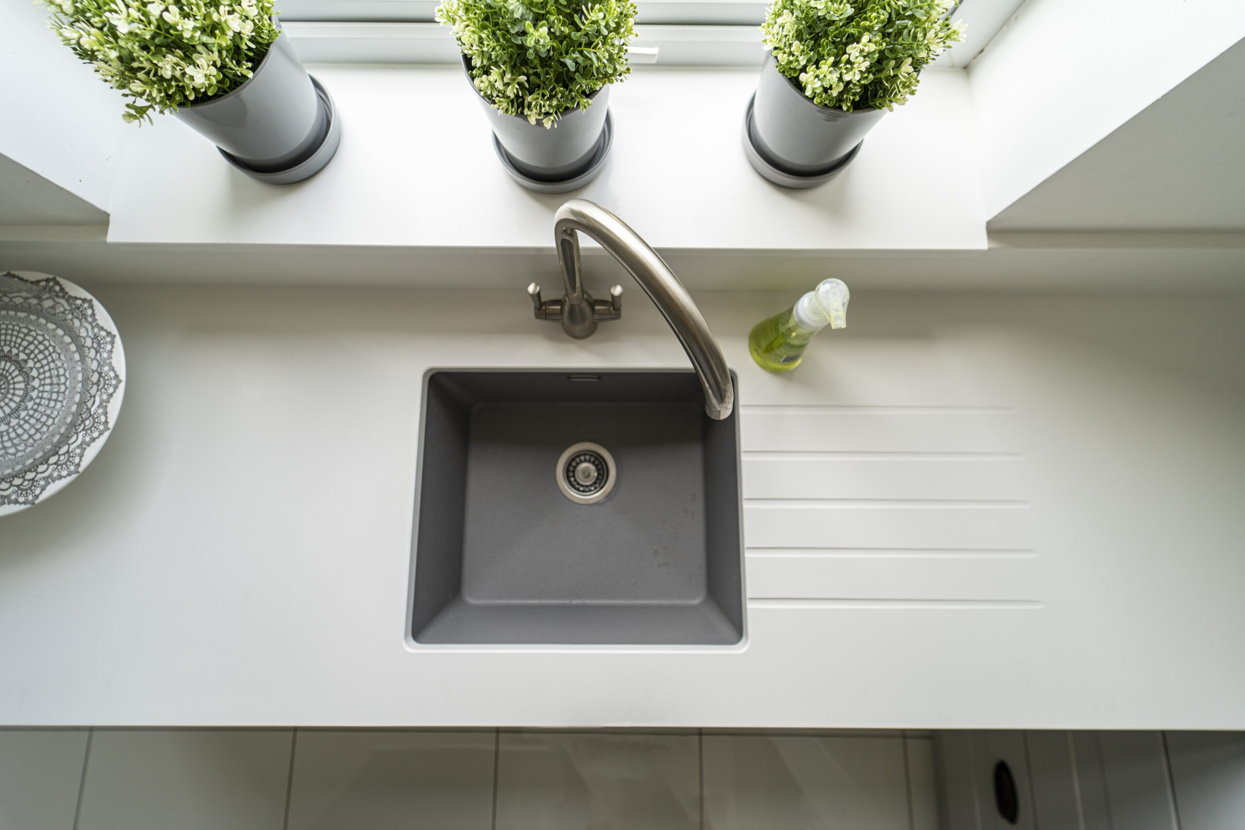Classic White Quartz sink run with drainer grooves and an inset sink, showing a smooth white finish