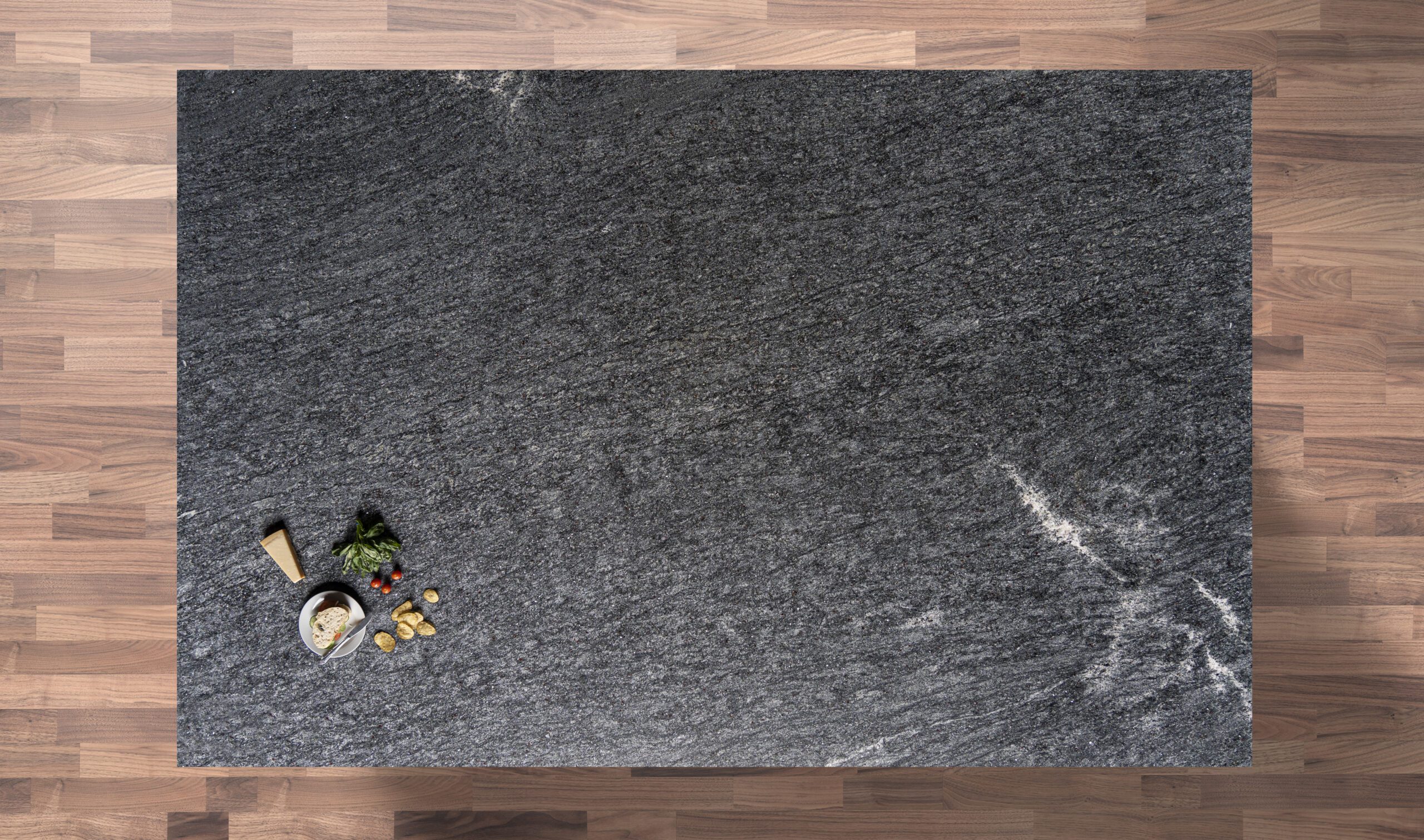 Overhead view of Diamond Galaxy Granite worktop showing a dark speckled pattern and subtle movement, photographed from above with a small styled tray near the edge.