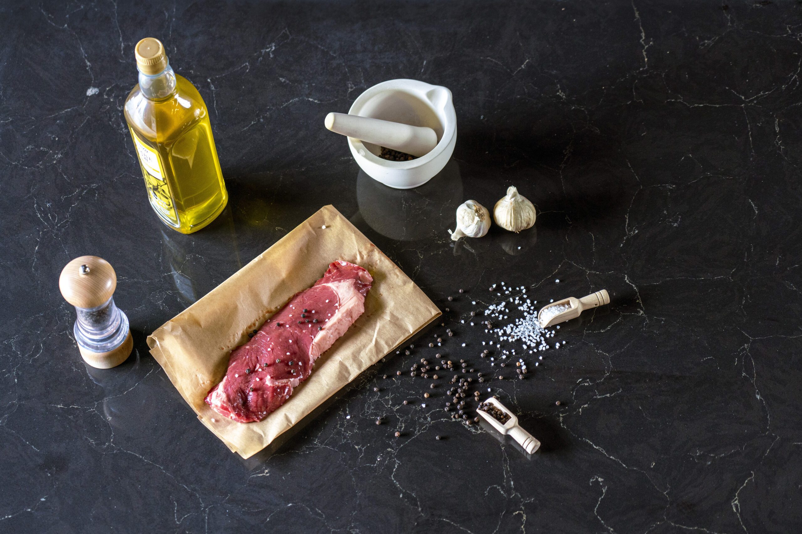 Emperor Black Quartz worktop surface with subtle veining shown with food preparation items on the countertop