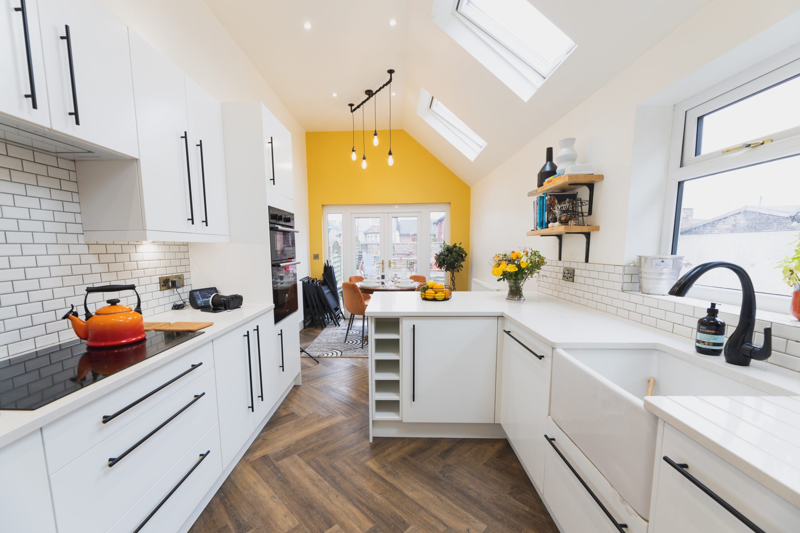 Long kitchen perspective showing Ice White Quartz worktops along white cabinets with a bright, smooth finish