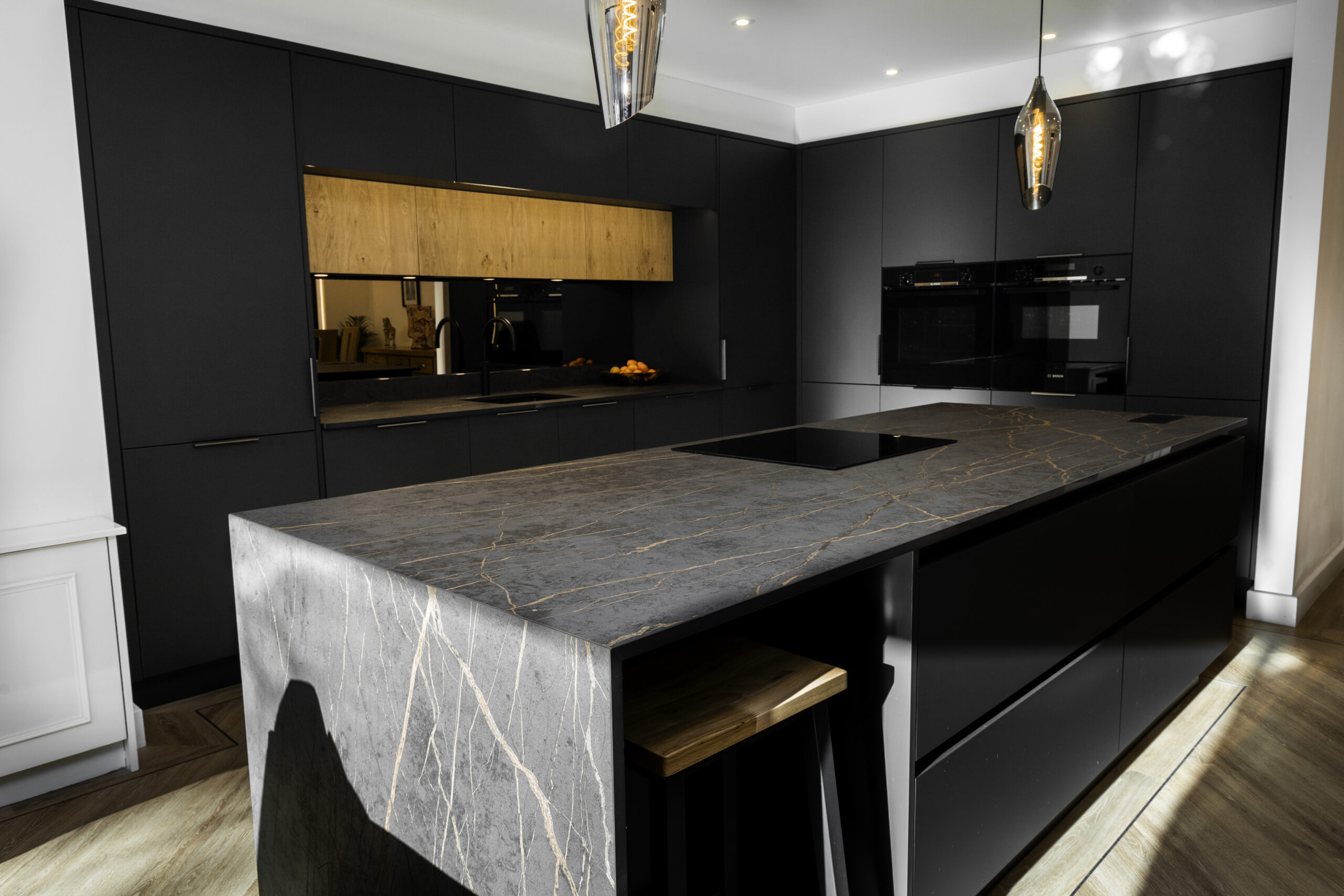 Laurent Porcelain worktops in a modern dark kitchen with bold veining and large central island