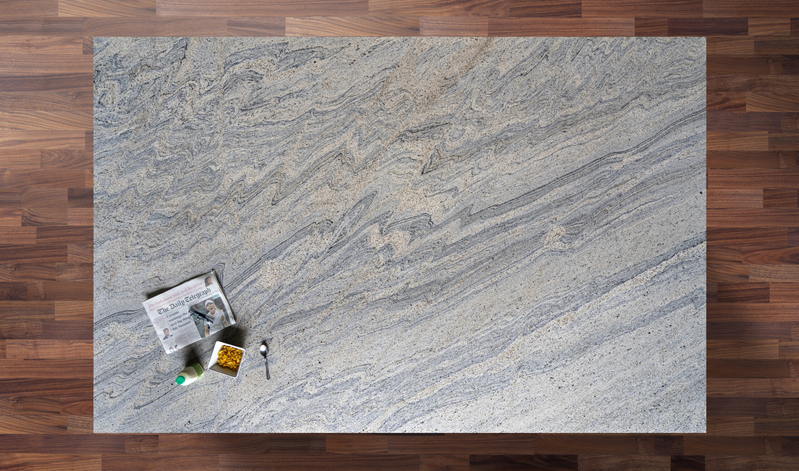 Overhead view of Ivory Wave Granite worktop showing flowing blue grey veining and natural movement, photographed from above with a small styled tray in the corner.