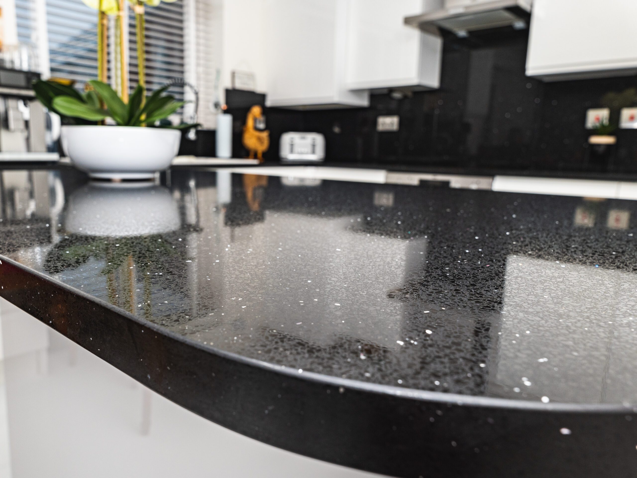Black Starlight Quartz worktop close-up showing reflective sparkle and a rounded island edge