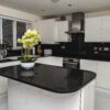 Wide kitchen view featuring a Black Starlight Quartz island with a curved end and subtle sparkle finish