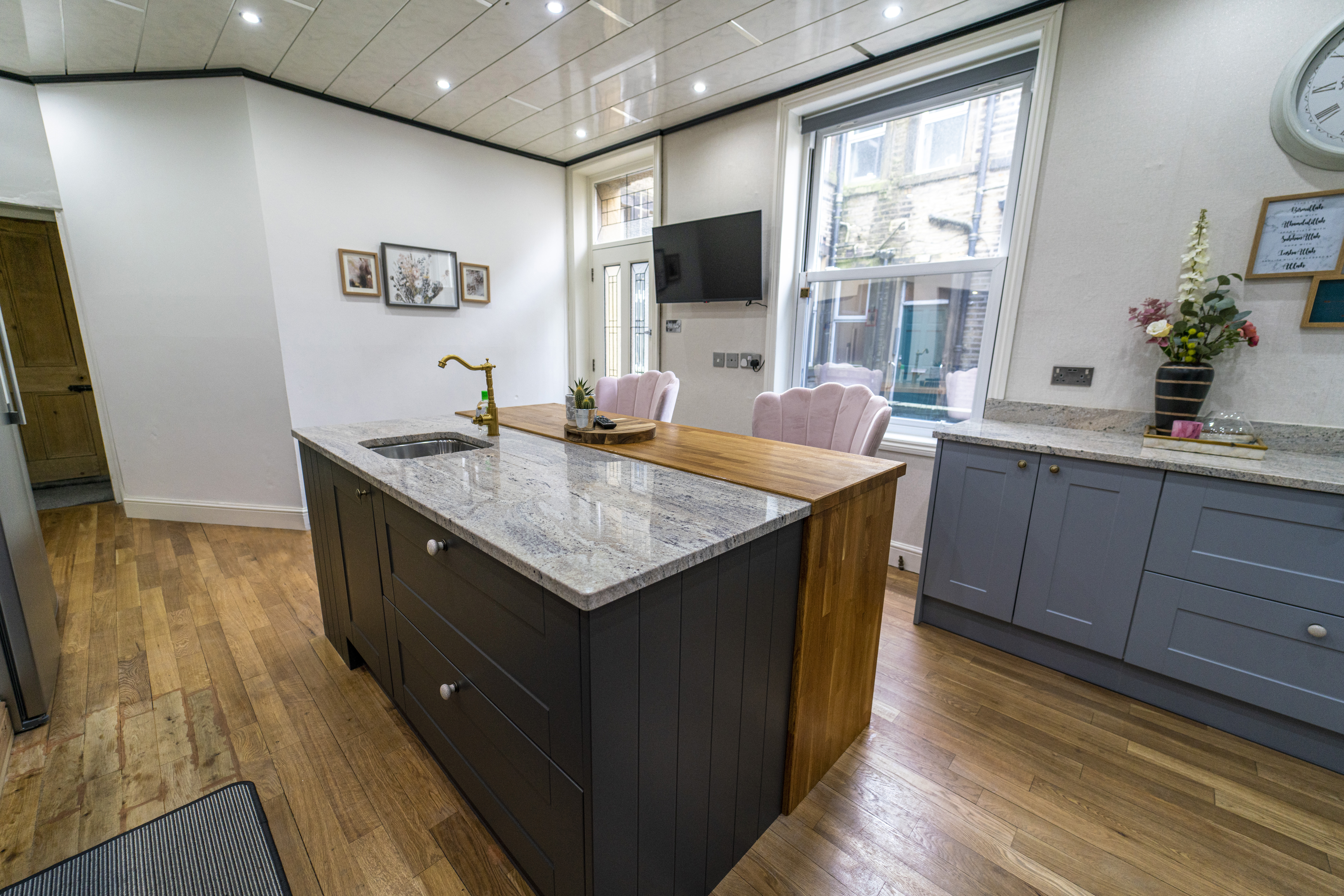 Front corner view of an Ivory Fantasy Granite island worktop with seating space, showing the polished surface and natural movement in the Granite.
