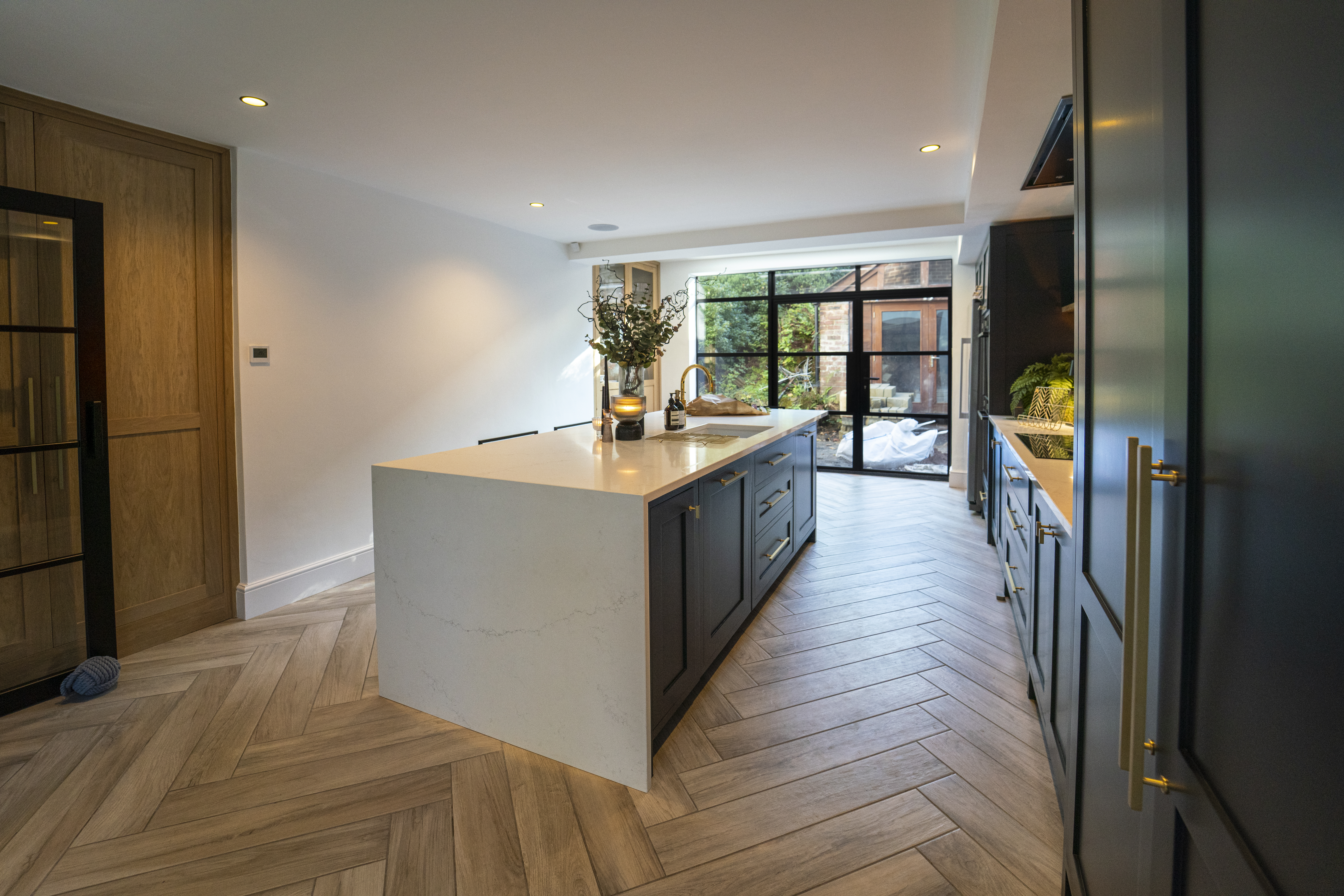 Olympus White Quartz island in an open-plan kitchen with soft grey veining and a bright surface finish