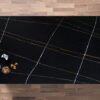 Sahara Noir Quartz worktop shown from above with black surface, fine grid lines and gold-toned veining running across the slab