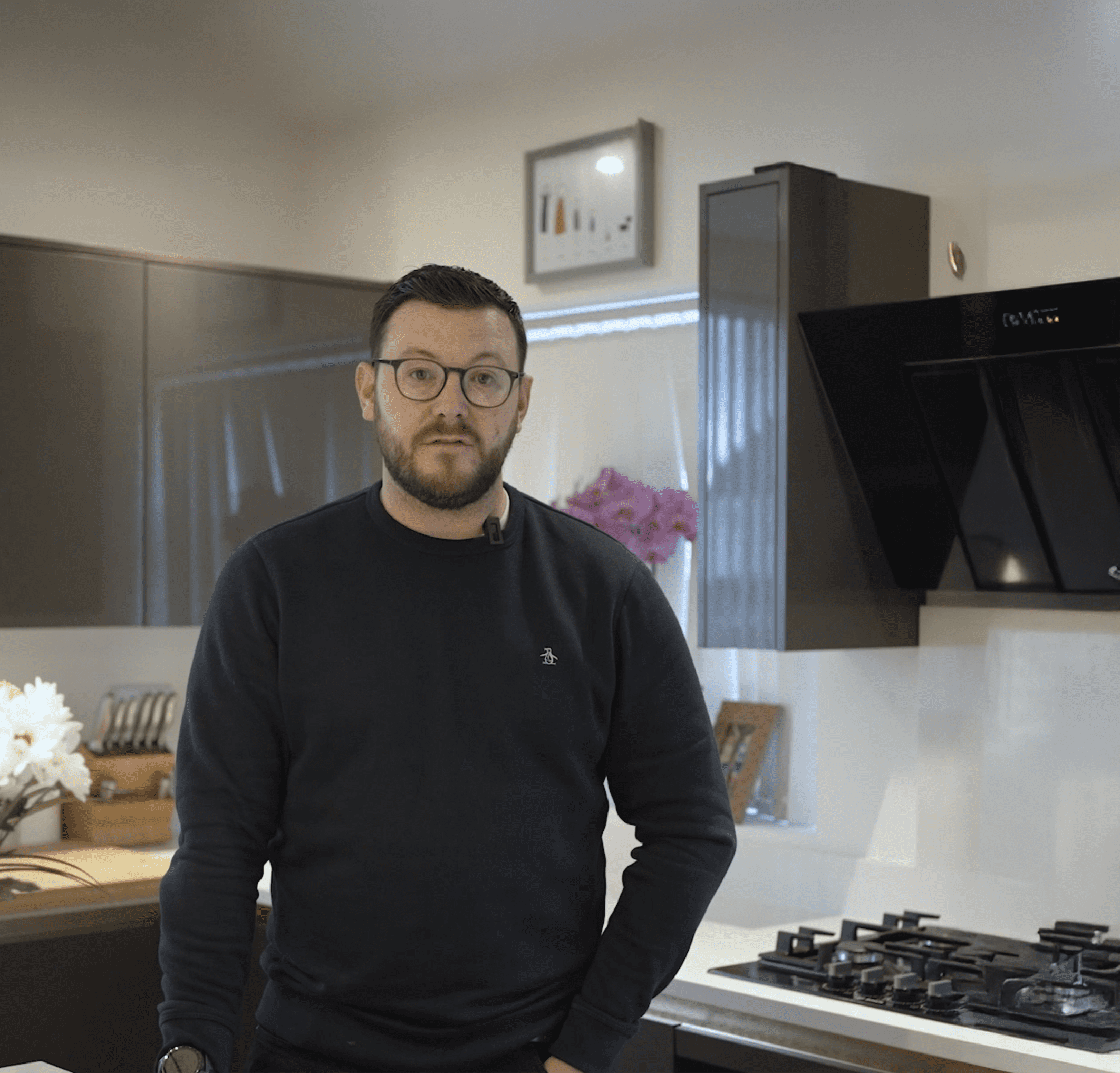 David standing in his kitchen beside an Imperial White Quartz worktop with a built-in gas hob