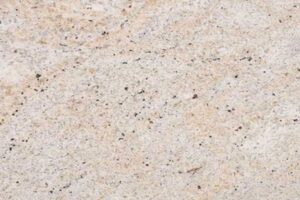 Close up slab photo of Ivory Fantasy Granite showing light beige tones with fine speckling and natural colour variation.