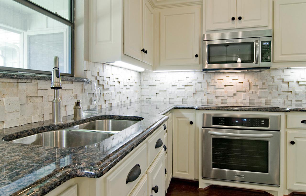 Traditional kitchen view with Sapphire Brown Granite worktops on cream cabinetry, showing the polished Granite surface around the sink and cooking area.
