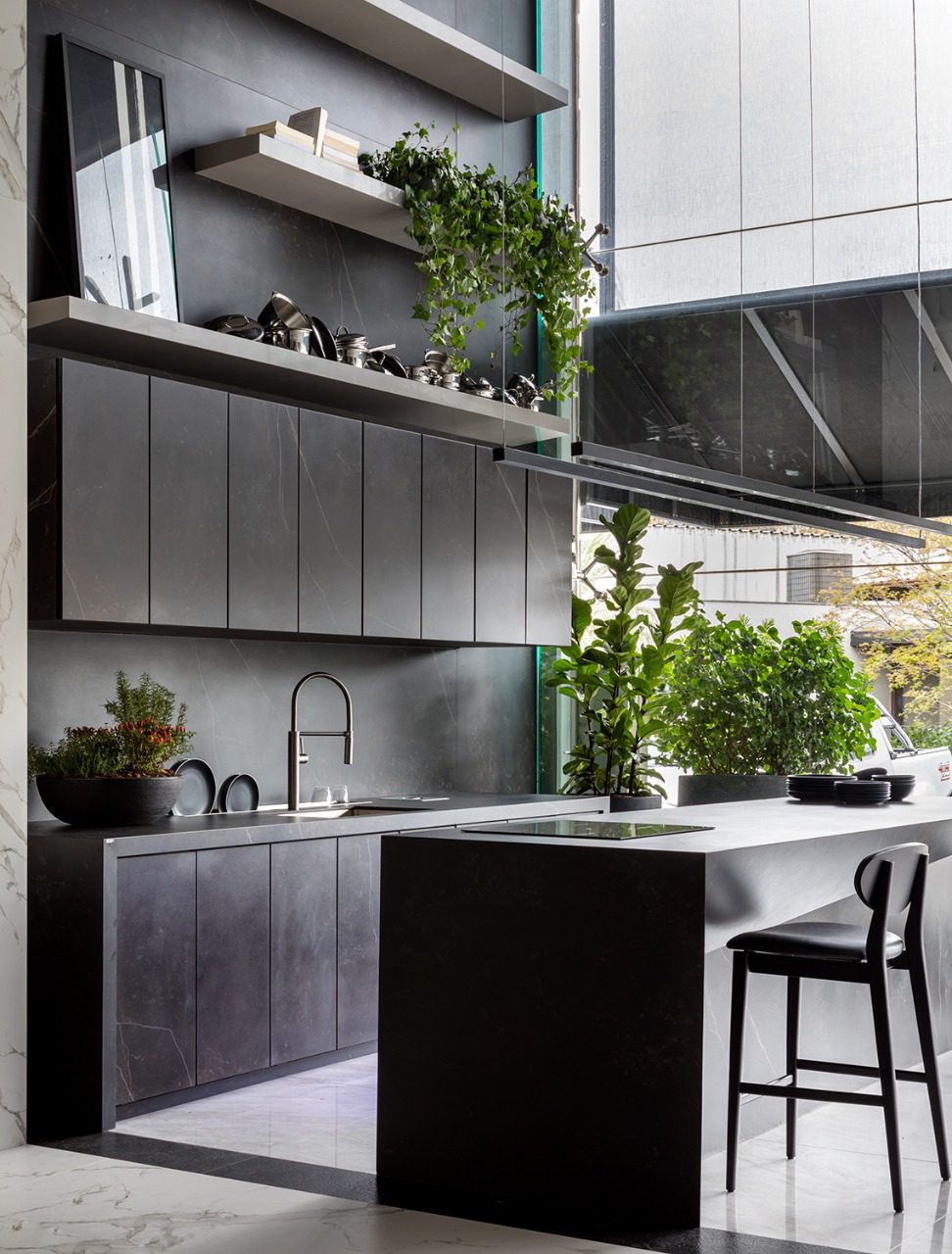 Kelya Porcelain worktops in deep charcoal with white veining in a modern kitchen with island and plants