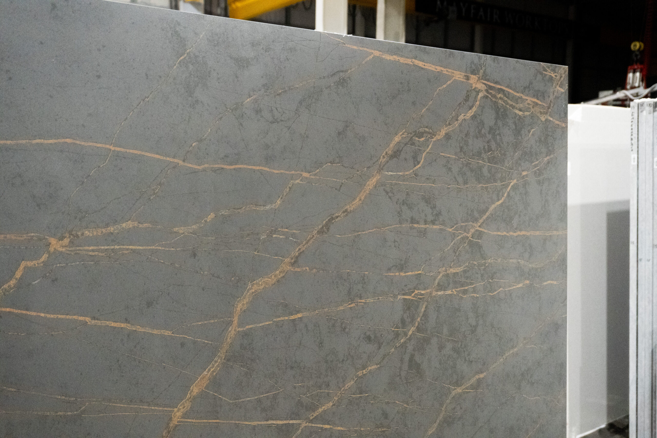 Gold Laurent Porcelain surface close-up with bold gold veining across a dark grey stone-look background