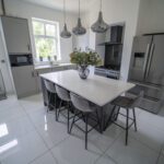 Modern kitchen with a Classic White Quartz island worktop and seating, showing a smooth white surface finish