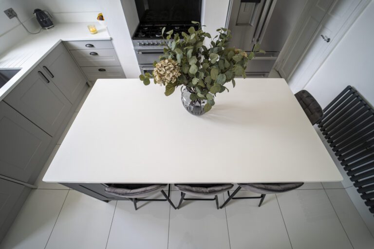 Overhead view of a Classic White Quartz kitchen island showing a smooth bright surface with seating below