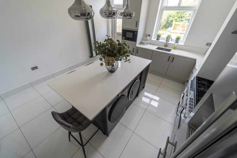 Angled view of a Classic White Quartz island worktop with seating, showing a smooth bright surface