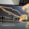 Noir St Laurent Porcelain worktop and splashback installed with bold gold and copper veining, shown above grey kitchen units with a socket on the wall.