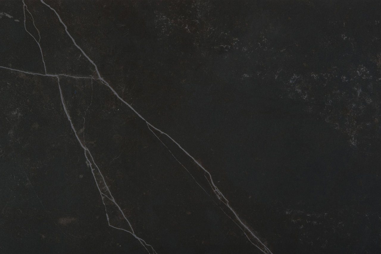 Kelya Porcelain close up in deep charcoal featuring a prominent white vein and soft speckled texture
