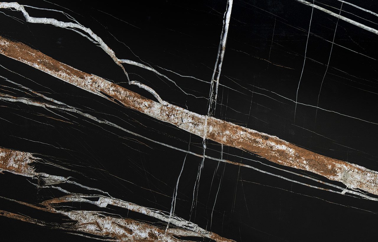 Noir St Laurent Porcelain worktop slab close up showing deep black surface with bold gold veining, styled with food and accessories