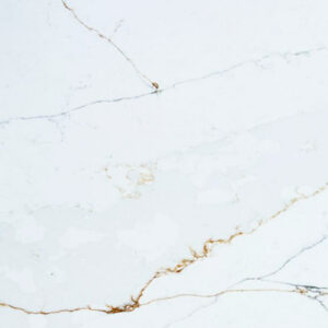 Close-up of Ethereal Calacatta Quartz slab showing gold veining and soft grey movement on a bright white polished surface