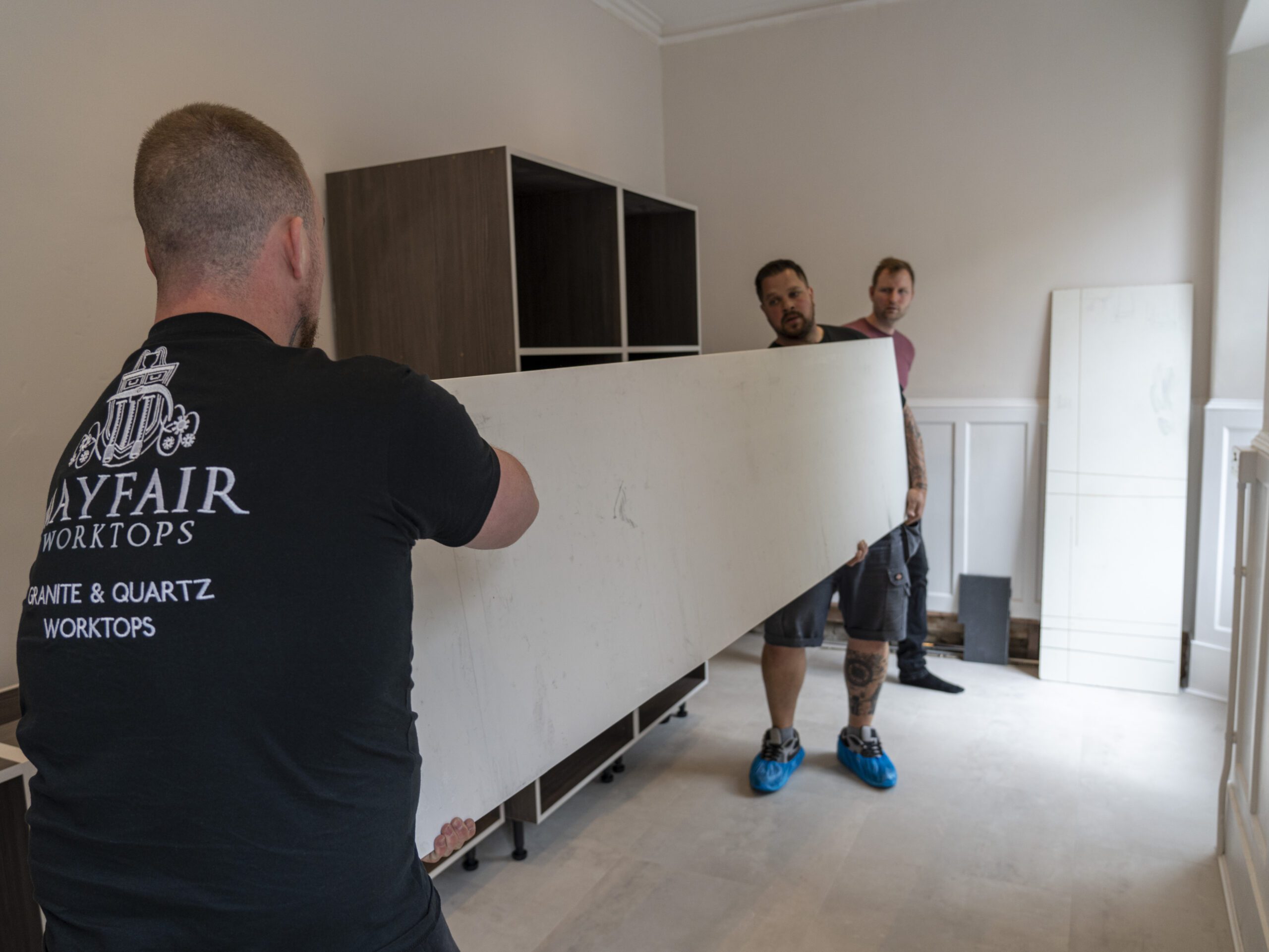 Stonemason preparing Carrara Quartz worktop area during installation