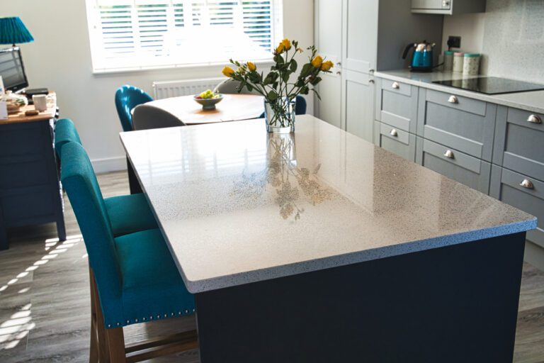 White Starlight Quartz kitchen island with subtle sparkle and vase of flowers in a modern kitchen