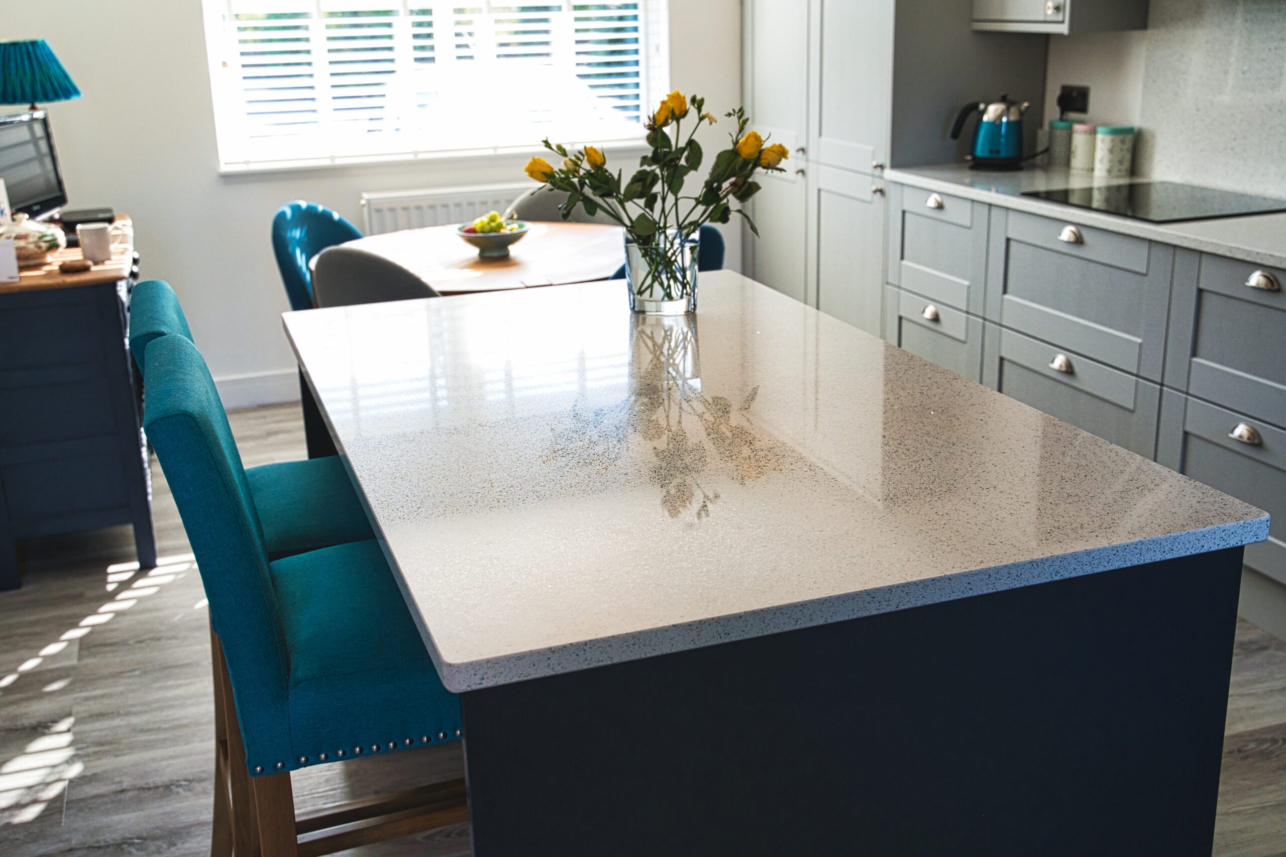 White Starlight Quartz kitchen island with subtle sparkle and vase of flowers in a modern kitchen