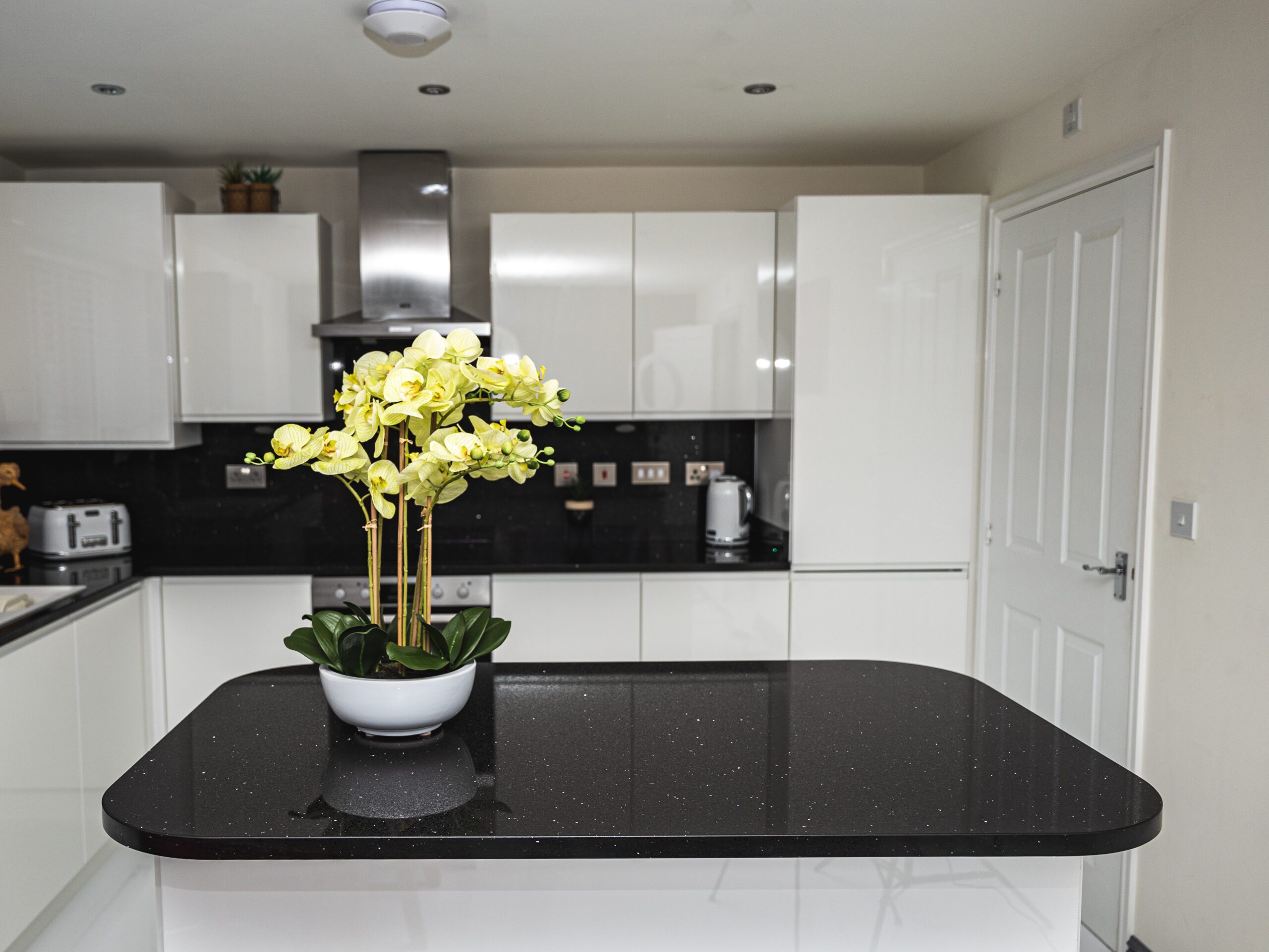 Modern kitchen with a Black Starlight Quartz island worktop showing a deep black surface with subtle sparkle